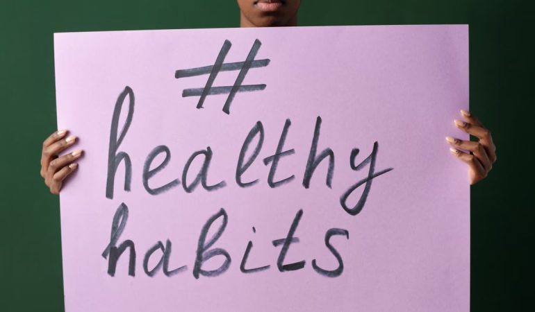 Person holding a "#healthyhabits" sign, emphasizing wellness.