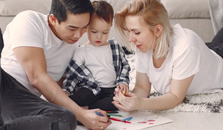 Loving family creating art together, fostering play and connection indoors.