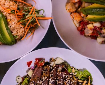 Three flavorful dishes featuring seafood and avocado, plated creatively for a delightful meal.