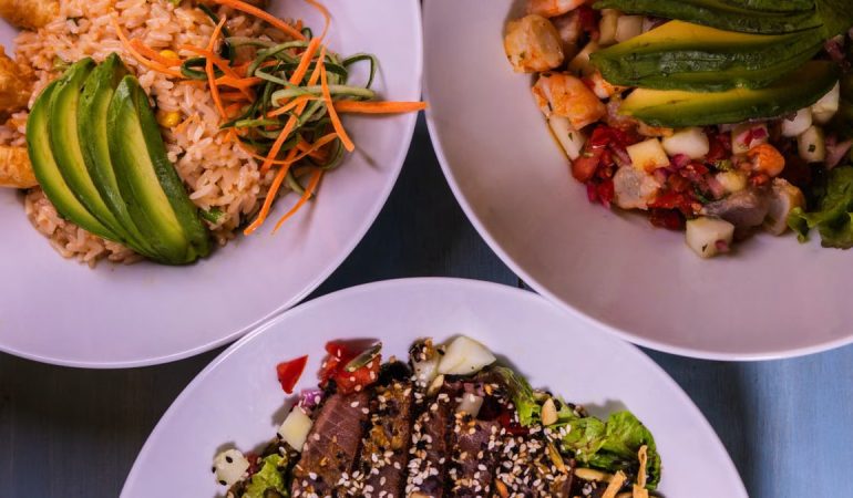 Three flavorful dishes featuring seafood and avocado, plated creatively for a delightful meal.